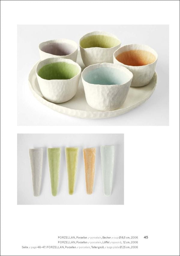 Collection of cream and black cups, saucers and vases, on white and grey cover, of 'Doris Bank, Table Art in Stoneware and Porcelain', by Arnoldsche Art Publishers.