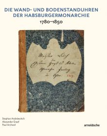 White lock face with gold mechanism, on black cover of 'Die Wand- und Bodenstanduhren der Habsburgermonarchie, 1780–1850', by Arnoldsche Art Publishers.