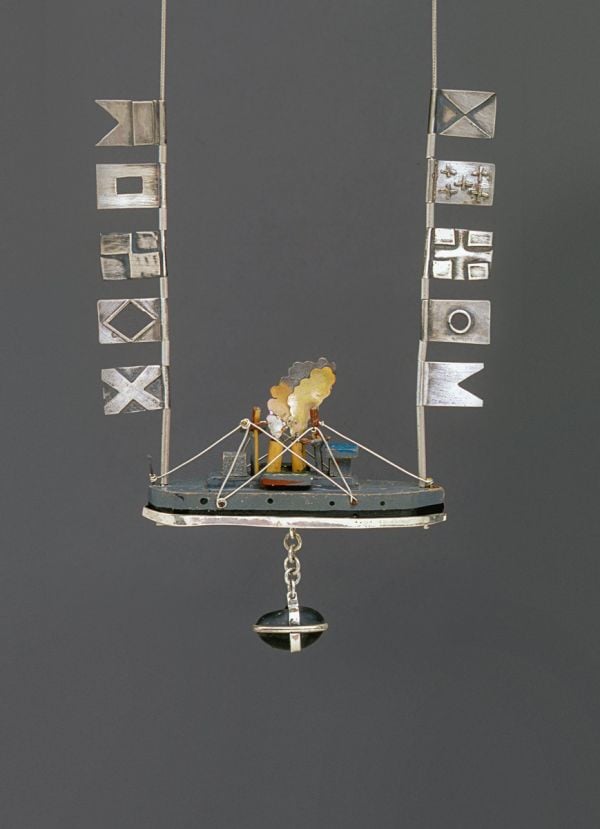 Book cover of North by Northwest, The Jewelry of Laurie Hall, with a jewelry piece made of wooden tube shapes, and dark metal pendants. Published by Arnoldsche Art Publishers.