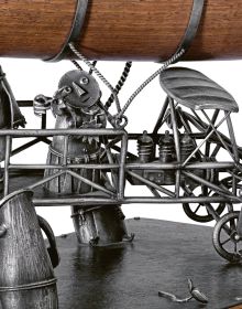 Book cover of Taming the Beast: Silver by Earl Krentzin, featuring a silver sculpture of open roofed car with bird at wheel, and creature balancing on orange egg to rear. Published by Arnoldsche Art Publishers.