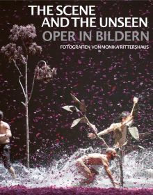 Book cover of The Scene and the Unseen, Opera in Pictures. Photographs by Monika Rittershaus, with a Opera theater production, with three windswept figures with water splashing at feet. Published by Arnoldsche Art Publishers.