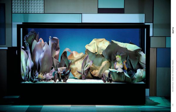 Book cover of The Scene and the Unseen, Opera in Pictures. Photographs by Monika Rittershaus, with a Opera theatre production, with three windswept figures with water splashing at feet. Published by Arnoldsche Art Publishers.