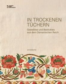 Off-white cloth with floral embroidery to bottom, 'IN TROCKENEN TÜCHERN', in gold font above, by Arnoldsche Art Publishers.