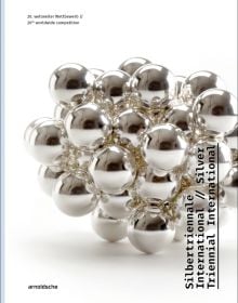 Silver metal ball bearings fused together, on white cover of 'Silver Triennial International, 20th Worldwide Competition', by Arnoldsche Art Publishers.
