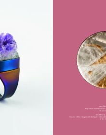 Blue book cover of Gerti Machacek, Jewellery Sculpture, featuring an oxidised copper jewellery piece, shaped like an eye, with eyelashes. Published by Arnoldsche Art Publishers.