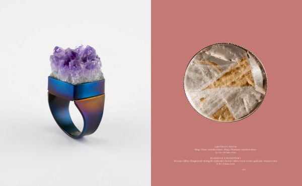 Blue book cover of Gerti Machacek, Jewellery Sculpture, featuring an oxidised copper jewellery piece, shaped like an eye, with eyelashes. Published by Arnoldsche Art Publishers.