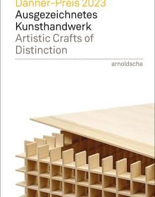 White book cover of Danner-Preis 2023 / Danner Prize 2023, Ausgezeichnetes Kunsthandwerk / Artistic Crafts of Distinction with a cube made of slats of wooden slates. Published by Arnoldsche Art Publishers.