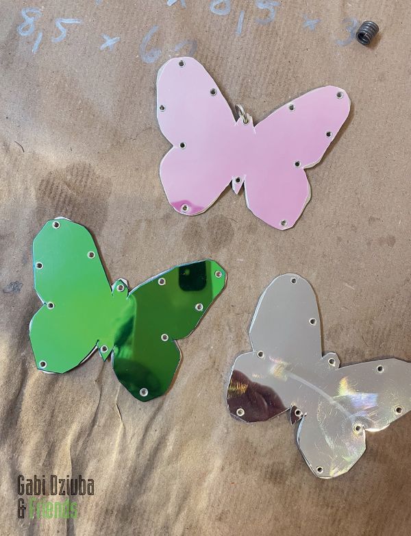 Book cover of Gabi Dziuba & Friends, with three shiny butterfly shaped pieces. Published by Arnoldsche Art Publishers.