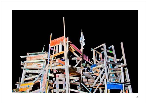 Mint green crown shaped structure tied down with rope, next to street building, on landscape cover of 'Joyful Architecture, European Architectural Photography Prize 2019', by Avedition Gmbh.