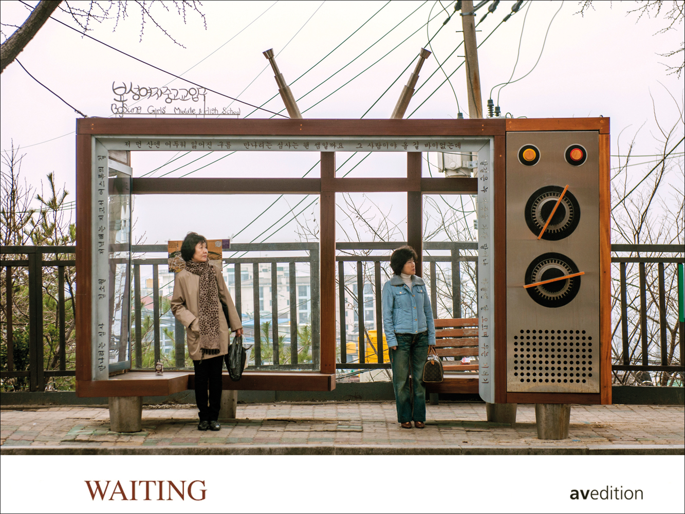 Two Asian women waiting outside a quirky bus stop, made to look like a portable radio, on landscape cover of 'Waiting, People in Transit', by Avedition Gmbh.