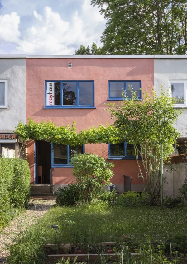 Orange door with key in lock, on cover of 'mayhaus, Das Musterhaus des Neuen Frankfurt', by Avedition Gmbh.
