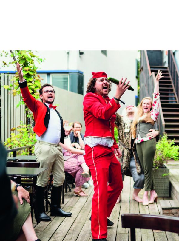 Book cover of Event Design Yearbook 2022 / 2023, with an exhibition space, and a man looking at figure with wings fighting figure with sword. Published by Avedition Gmbh.