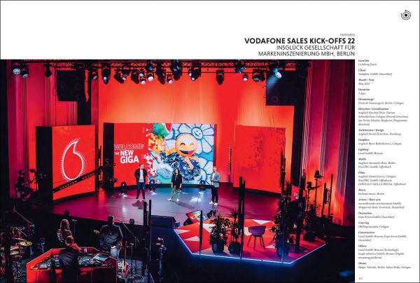 Book cover of Experience & Event Design 2023 / 2024, with exhibition space with people looking up at blue lights and umbrellas. Published by Avedition.