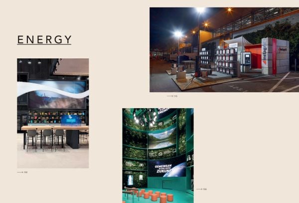 Book cover of Brand Experience & Trade Fair Design Annual 2023/24, with an interior of design exhibition with tropical foliage and metal tubes descending from above. Published by Avedition Gmbh.