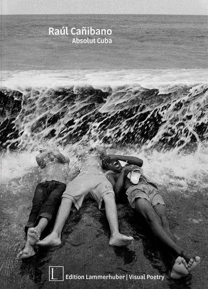 Black and white action shot of 3 figures laying on beach being smothered by crashing sea waves and Raúl Cañibano Absolut Cuba in small white font above