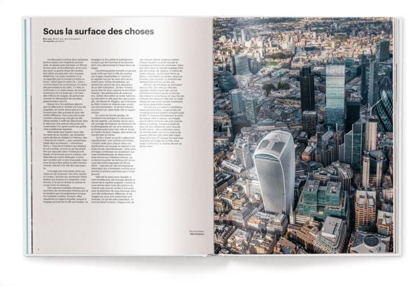 Low angled shot of aeroplane flying overhead London skyscrapers, white cover, streets of london, on black font above.