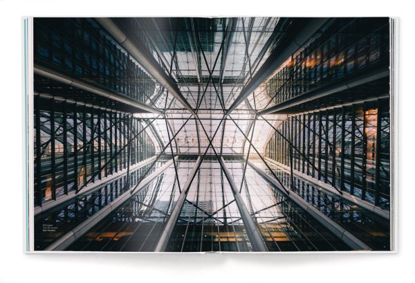 Low angled shot of aeroplane flying overhead London skyscrapers, white cover, streets of london, on black font above.