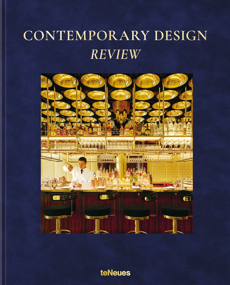 Luxury interior of Isabel London bar, bartender pouring cocktail, on blue cover, 'CONTEMPORARY DESIGN REVIEW', in gold font above.