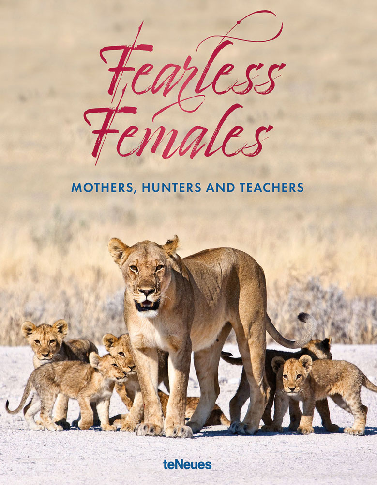 Lioness with pack of cubs standing on dry ground with Fearless Females in dark pink script font above