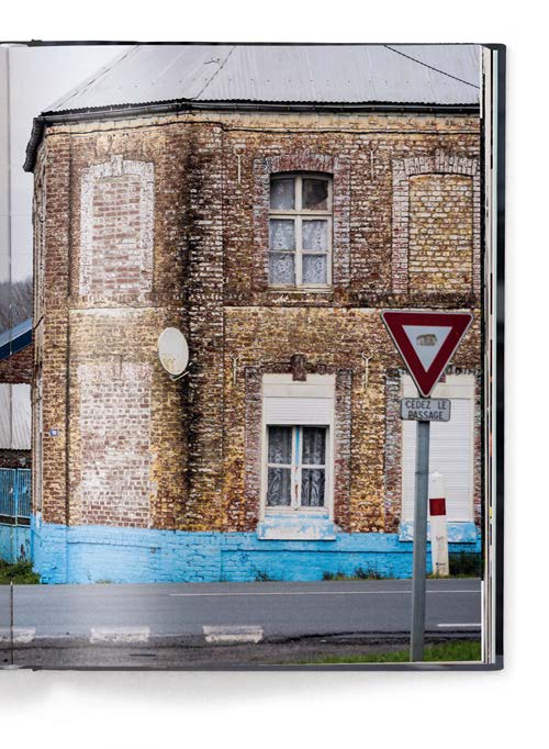 Book cover of Icons of Cycling, featuring two road racing cyclists biking on road with sand hills behind. Published by teNeues Books.