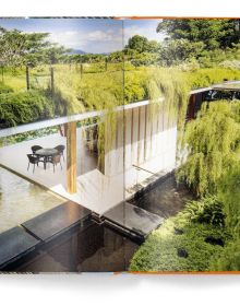 Ground perspective of 3 wood buildings with trees spurting out top, LIVING ROOFS in orange font near centre