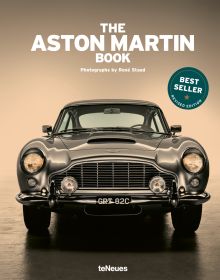 Book cover of The Aston Martin Book, with the front end of silver Aston Martin DB5 with headlights on. Published by teNeues Books.