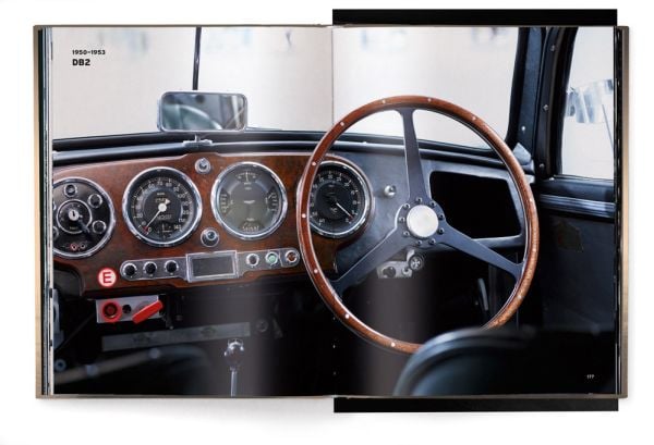 Book cover of The Aston Martin Book, with the front end of silver Aston Martin DB5 with headlights on. Published by teNeues Books.