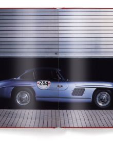 Front of red Mercedes-Benz 300 SL with open gullwing doors, ICONICARS MERCEDES-BENZ 300 SL, in white font above.