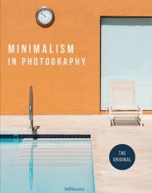 Exterior space, corner of swimming pool with cream deck chair, orange wall with clock, Minimalism in Photography in white font to upper left.