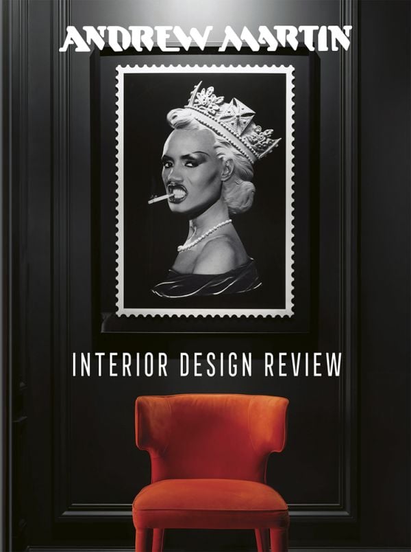 Book cover of Andrew Martin Interior Design Review Vol. 26, featuring a framed picture of Grace Jones wearing crown, with cigarette between teeth, hanging above an orange chair. Published by teNeues Books.