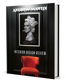 Book cover of Andrew Martin Interior Design Review Vol. 26, featuring a framed picture of Grace Jones wearing crown, with cigarette between teeth, hanging above an orange chair. Published by teNeues Books.