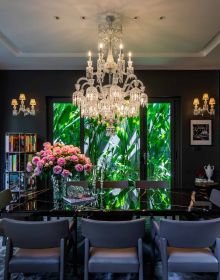 Luxurious interior with long dining table, art deco velvet chairs, chandelier above, THÁI CÔNG A PASSION FOR AESTHETICS, in gold font to top and bottom edge of black cover.