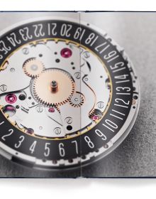 Watch mechanism with blue filter on cover of 'The Watch Book – Oris', by teNeues Verlag.
