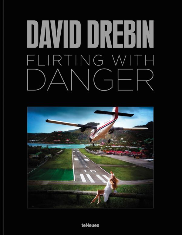 Book cover of Flirting with Danger, with a photograph titled 'Risky Landing', with a small aircraft heading toward runway with lady in white dress sitting on fence. Published by teNeues Books.