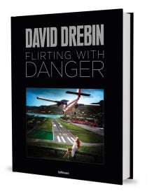 Book cover of Flirting with Danger, with a photograph titled 'Risky Landing', with a small aircraft heading toward runway with lady in white dress sitting on fence. Published by teNeues Books.