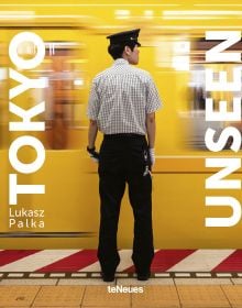 Book cover of Tokyo Unseen, with a subway staff member standing next to speeding yellow train. Published by teNeues Books.
