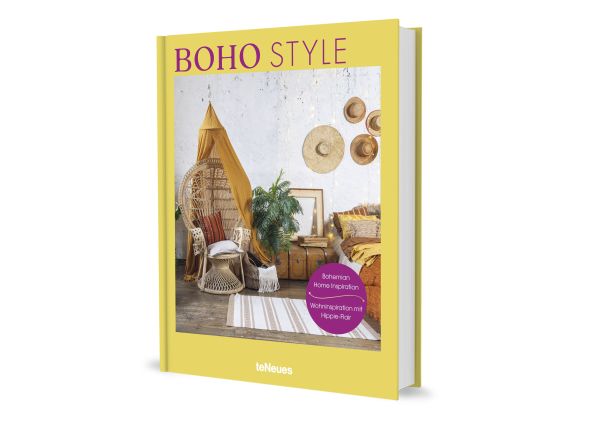 Large rattan chair draped with mustard coloured ceiling fabric, floppy hats on wall, on yellow cover of 'Boho Style, Bohemian Home Inspiration', by teNeues Books.