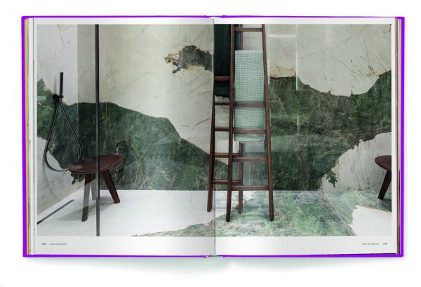 Aerial view of wood floor with woven rug, wooden plate with green palm leaf, on purple cover of 'Eco Materials, Decorating with Ecological Materials', by teNeues Books.