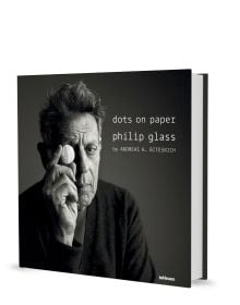 Book cover of dots on paper, Philip Glass by Andreas H. Bitesnich, with the composer in dark jacket, holding circular piece of glass to right eye. Published by teNeues Books.