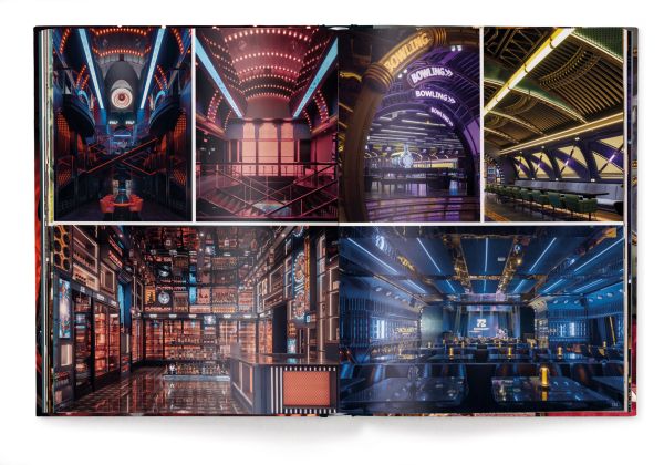 Interior living room of La Maison Semonville with stone fireplace, framed paintings and plush furniture, on cover of 'Andrew Martin Interior Design Review Vol. 27', by teNeues Books.