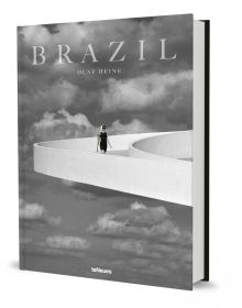 Book cover of Olaf Heine's Brazil, with a figure walking down a white raised platform on modern building, with sky behind. Published by teNeues Books.
