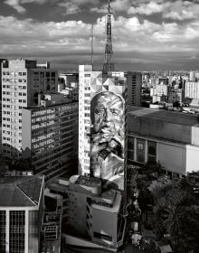 Book cover of Olaf Heine's Brazil, with a figure walking down a white raised platform on modern building, with sky behind. Published by teNeues Books.