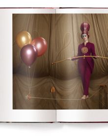 Female circus performer with drawn on extended eyelashes, braided jacket, on cover of 'Circesque', by teNeues Books.