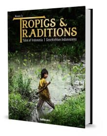 Book cover of Manolo Ty's Tropics & Traditions: Tales of Indonesia, with a young child walking through a river. Published by teNeues Books.