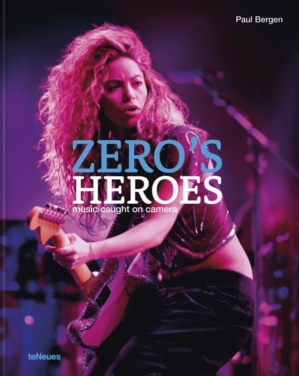Book cover of Paul Bergen's Zero’s Heroes: Music Caught on Camera, featuring Shakira performing on stage with a guitar. Published by teNeues Books.