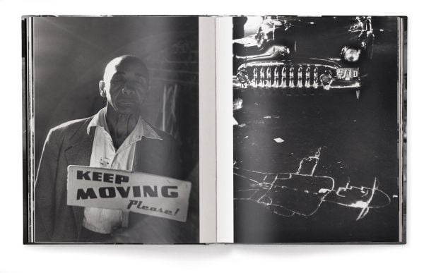 Man wearing white sailor's clothes and hat, with his back to viewer, staring across busy city street, on cover of 'Elliott Erwitt’s New York', by teNeues Books.