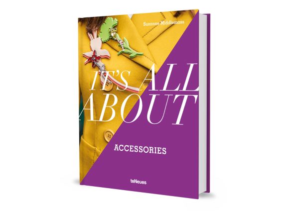 Book cover of Suzanne Middlemass's It’s All About Accessories, with a model wearing a yellow jacket and two large brooches to right lapel. Published by teNeues Books.