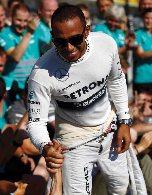 Book cover of The Stylish Life: Grand Prix, featuring a model in 60s clothes standing on race track with car and driver behind. Published by teNeues Books.