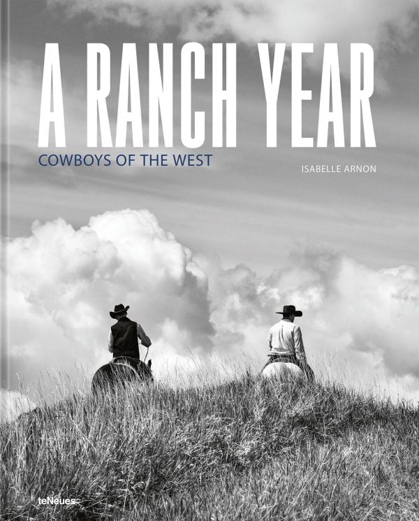 Book cover of A Ranch Year: Cowboys of the West; featuring two figures on horseback riding over a grassy mound, away from the viewer. Published by teNeues Books.