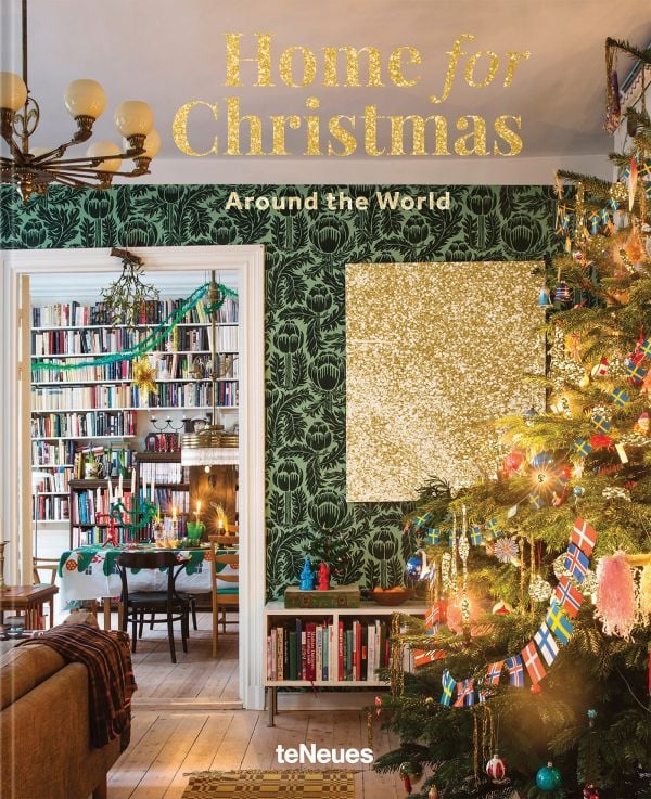 Book cover of Home for Christmas - Around the World; featuring a festive interior with a Christmas tree decorated in country flags. Published by teNeues Books.